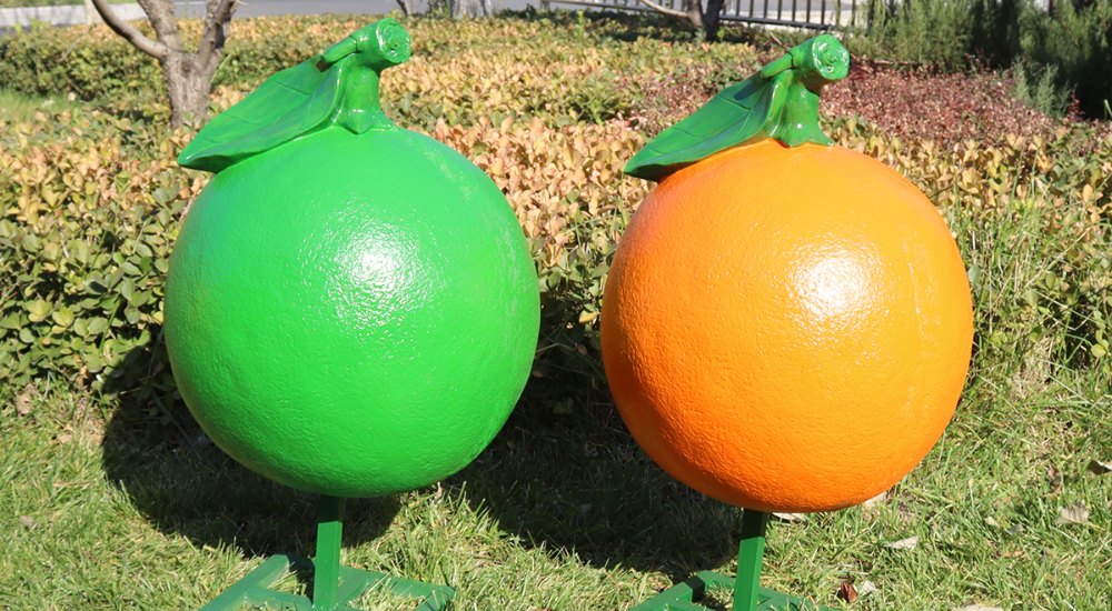 Выставка скульптур зеленого и желто-оранжевого цвета